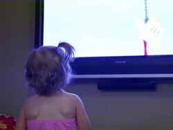 Toddler watches TV monitor, dances with Mickey Stock Footage