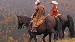 DS Male and female rancher riding horses down the hill Stock Footage
