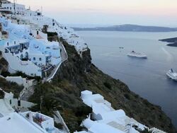 Dome of the local church and the white washed houses of Thira overlooking Cruise ships and the Aegean Sea on the Island of Santorini, Greece, Europe Stock Footage