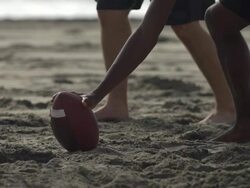 A group of guys playing flag football on the beach. - Slow Motion Stock Footage