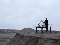 WS Young businessman in black suit holding picture frame on bluff next to table in rural area at dusk / Maple Grove, Minnesota, United States Stock Footage