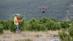 LD Two UAV pilots landing a drone on hilltop Stock Footage