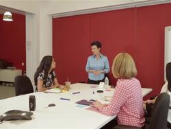 Middle aged female executive presents idea in front of diverse group of female colleagues Stock Footage