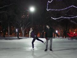 Caucasian couple skates together on a winter night. Stock Footage