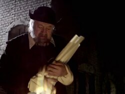 A man in period clothing burns pages of works by Nostradamus in a reenactment. Stock Footage