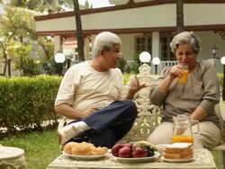 Senior couple having breakfast in a lawn  Stock Footage