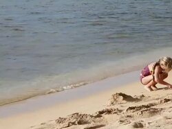 MS Young girl playing in sand on beach / Kauai, Hawaii, United States Stock Footage