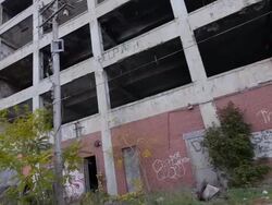 Exterior dolly view of abandoned auto assembly plant Stock Footage
