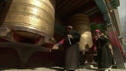 Tibetan women turn prayer cylinders. Stock Footage
