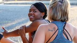 MS Smiling woman in discussion with friends while stretching before morning run Stock Footage