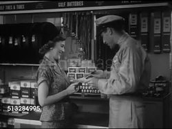 1952: SPONSOR BREAK: MS woman standing inside Gulf gas station w/ attendant in uniform helping her w/ map & tourgide [sic] card service, CU Female hand filling out name & address on tourgide card.   Early commercials. Instructional Video