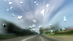 Raindrops trickle down a windshield as a vehicle speeds along a highway. Stock Footage