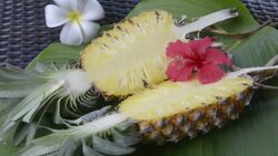 Woman arrange Hibiscus and Frangipani flowers at sliced Pineapple Stock Footage