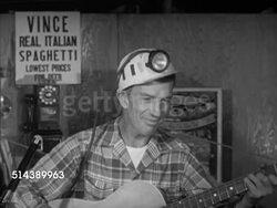 1952: THE SHANNOPIN CREW: VS The Shannopin crew, deckhands, walking up hill, entering restaurant in Morgantown, West Virginia. INT VS Dorsey Lewis w/ guitar singing, 'The Scared Coal Miner' song to crew (SOT). Steel industry Instructional Video