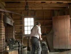 Costumed blacksmith interpreter at Mount Vernon, George Washington's home Stock Footage