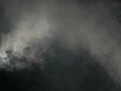 Heavy smoke dispersing against black background Stock Footage