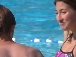 Teens at an outdoor swimming pool talk Stock Footage