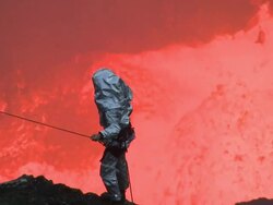 Lava erupts vigorously behind volcanologist , Marum Volcano, Ambrym Island, Vanuatu Stock Footage