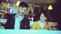 16mm film footage of young couple shopping for vinyl albums in record store Stock Footage