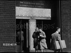 1947: ILLUMINATING COMPANY: CLEVELAND, OHIO: VS City streets, cars, pedestrians, people entering 'Cleveland Electric Illuminating Company' building. INT VS Workers in office, male posting up flyers for 'Cleveland.' Management headquarters Instructional Video