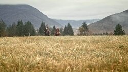 Two horseback riders riding on mountain meadow Stock Footage