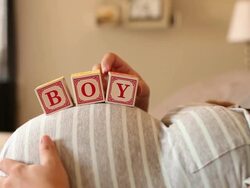 A pregnant women using blocks to spell the word BOY on her stomach. Stock Footage