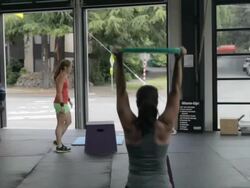 Adriane performs overhead lunge in forground; Jean Anne finishes box jumps in background. Stock Footage
