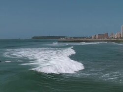 TS Surfer riding wave breaking into beach / Durban, Kwa Zulu Natal, South Africa Stock Footage