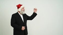 Adult senior businessman  showing a copy space in the Santa Claus hat on a grey background Stock Footage