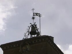 Bell and ornamental ironwork top the tower of Rome's Church of Santa Maria in Trastevere. Stock Footage