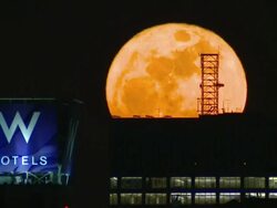 The harvest Full moon rises over the manhattan skyline showcasing the W hotel and adjacent skyscrapers. Stock Footage