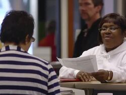 MS PAN Women job seekers standing and talking with clerk at counter of state run job center / Jackson, Michigan, United States  Stock Footage