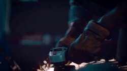 Man in motorcycle workshop grinding a piece of metal Stock Footage