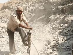 Indian manual worker at mining site with drill machine Stock Footage