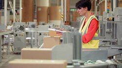 Worker inspecting cardboard boxes on production line in factory Stock Footage