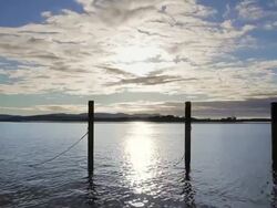 WS T/L Mooring posts stand like sentinels against clouds at Mallacoota Estuary / Mallacoota, Victoria, Australia Stock Footage