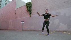 Cool tough young woman with purple mohawk practicing martial arts spinning kick in urban parking lot Stock Footage