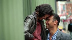 New York couple nuzzle heads outside green Soho storefront Stock Footage