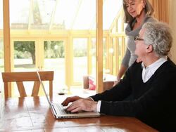 Mature male and female looking at laptop Stock Footage
