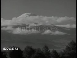 1939: MEXICO: ANCIENT ARCHITECT: MS Pyramid of the Sun. LA MS Aztec statue above tomb. WS Mountain, clouds, trees FG. HA WS Farmlands. VS Buildings, churches, bell tower, ancient towers. WS Crowded Mexican street, church building BG. Instructional Video