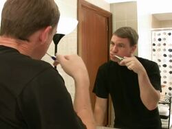Man brushes teeth in front of mirror Stock Footage