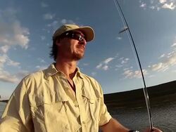 MS Man holding fishing rod while riding in inflatable boat at sunset / Iztapa, Guatemala Stock Footage
