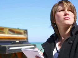 thoughtful young woman writing at the piano Stock Footage