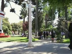 MS PAN Students in school uniforms and other people walking by in park / ChillÃŒÃn, Valle Central, Chile Stock Footage