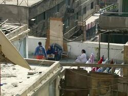WS HA Shot of two women talking on rooftop with children playing and laundry nearby / Cairo, Egypt Stock Footage