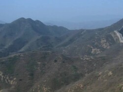 A view of mountains in China, then panning right to reveal a lengthy stretch of the Great Wall of China. Stock Footage