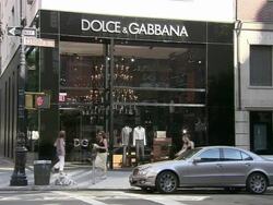 WS, Dolce & Gabbana store with traffic in foreground, Madison Avenue, New York City, New York, USA Stock Footage