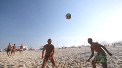 Brazilian footvolley team trap, set, and head soccer ball over net on Copacabana Beach Stock Footage