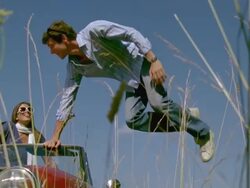 SLO MO, MS, Couple in red convertible in meadow, man jumping out of car, Saint Ferme, Gironde, France Stock Footage