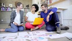 Creative business people reviewing and discussing proofs on office floor Stock Footage